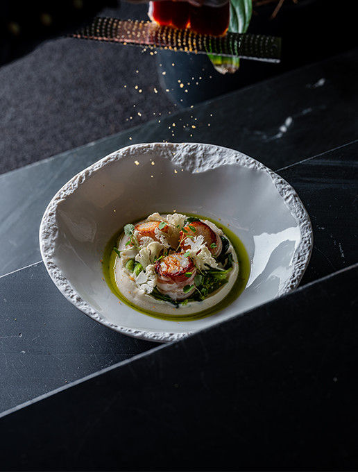 Refined dish of scallops prepared with an emulsion and crunchy vegetables, served at the restaurant Dans le Noir ?